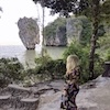 Someone seen from behind on a trail overlooking cliffs and water
