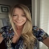 A person wearing a floral top, smiling